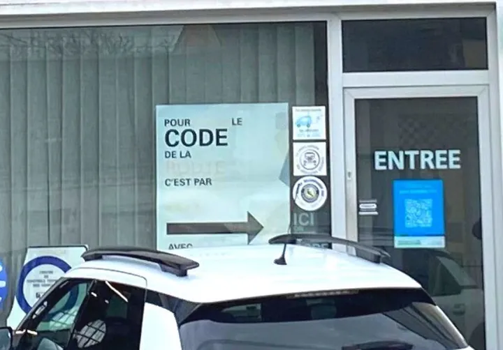 La vitrine du centre, avec le panneau « Pour le code de la route, c'est par ici » et la porte d'entrée