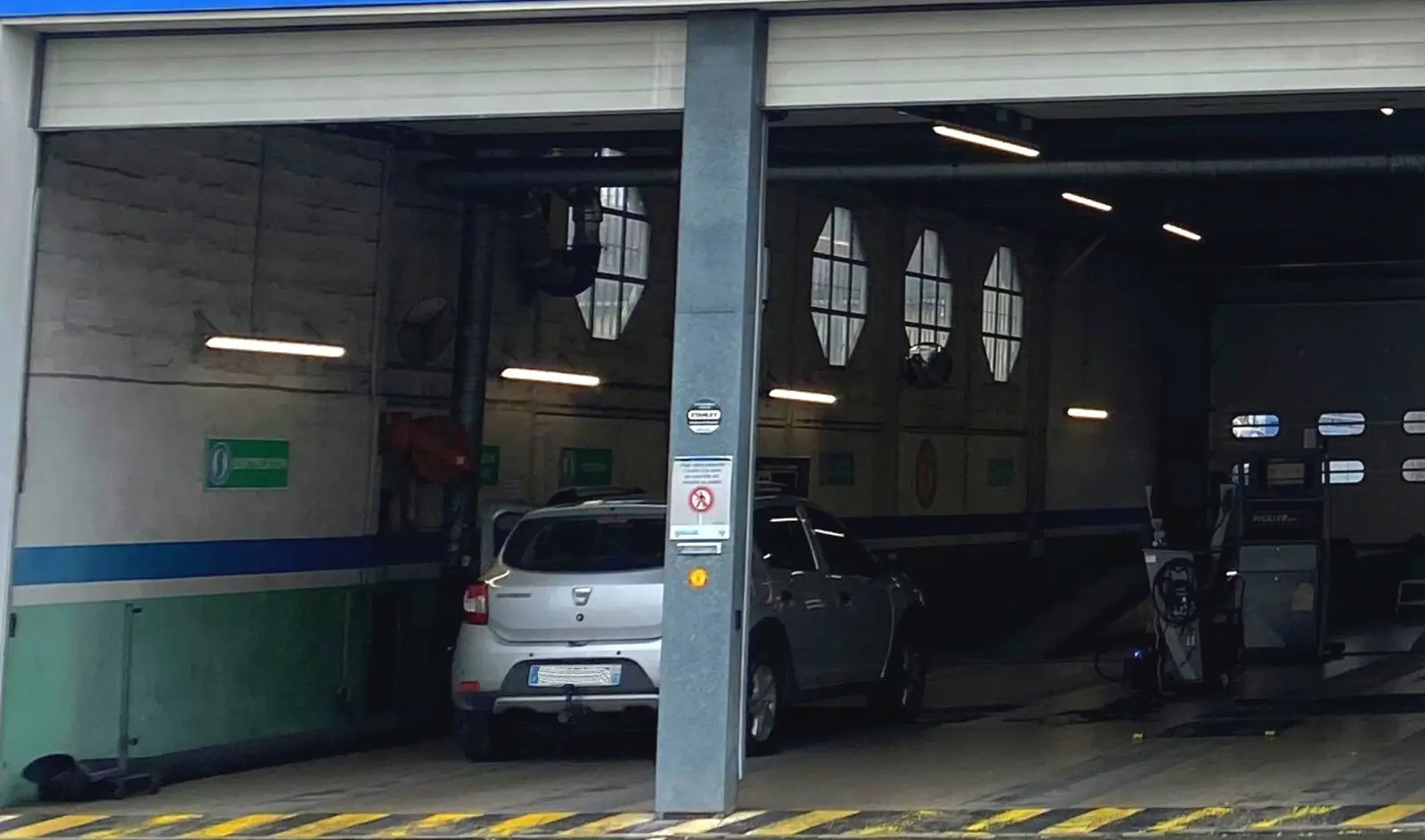 La piste de contrôle, une voiture sur la ligne, sous les fenêtres rondes de l'atelier